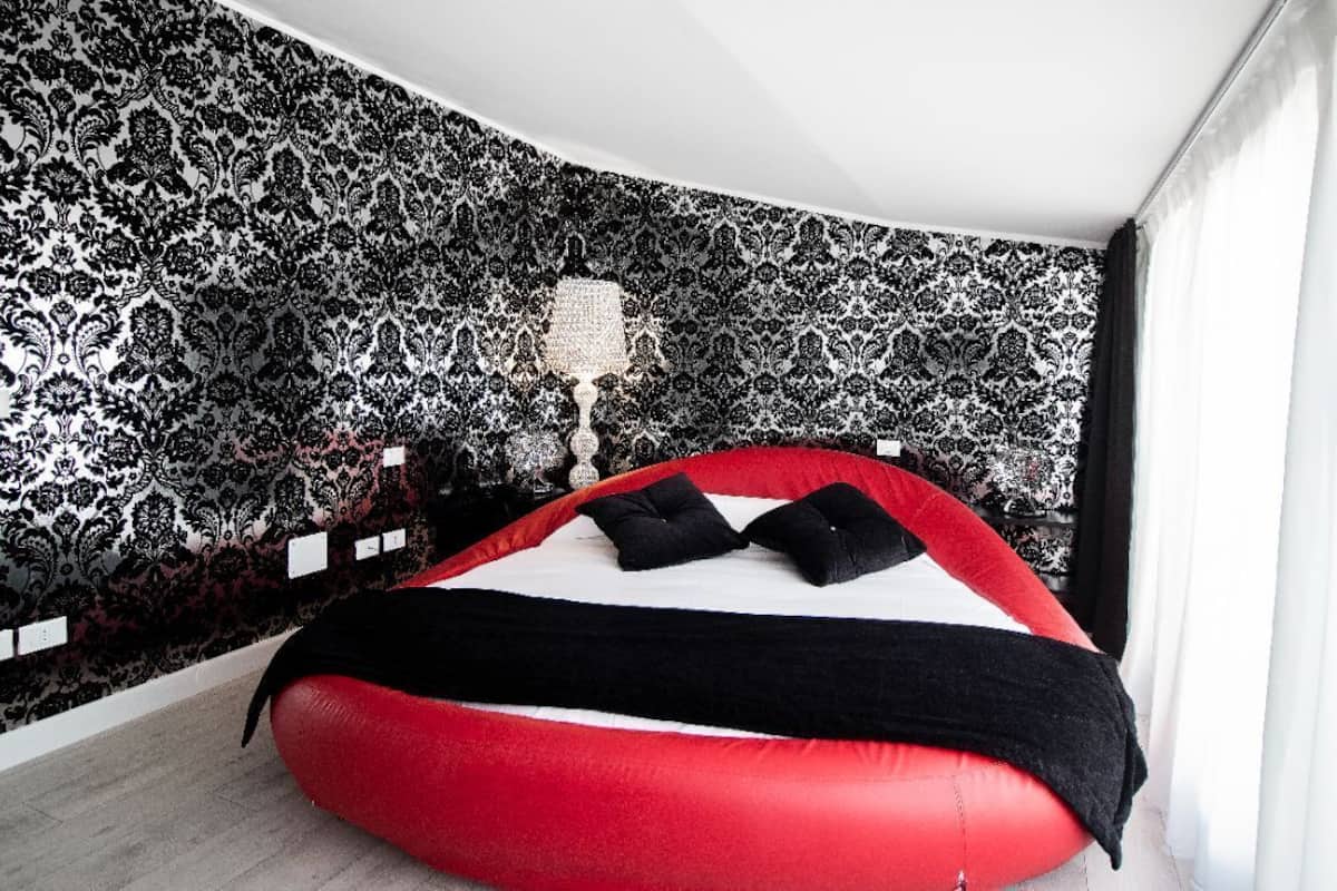 Ein Zimmer mit einem roten Sitzsack, einer schwarz-weißen Wandverkleidung und einer weißen Lampe.