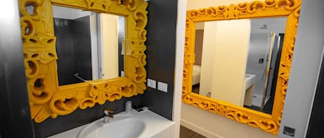 A bathroom with a white sink and ornate yellow mirrors.