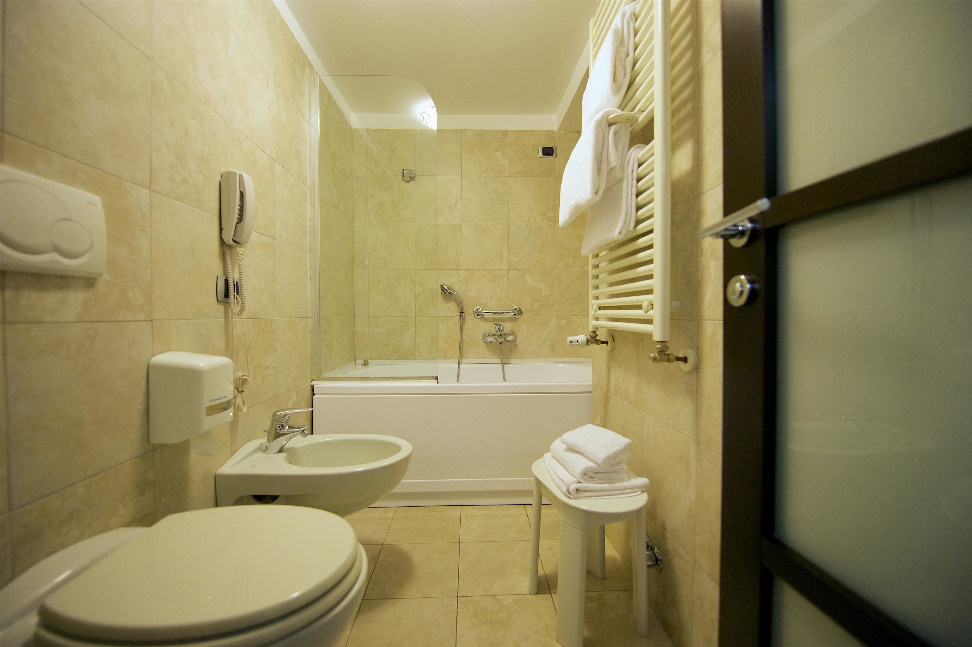 Une salle de bain comprenant des toilettes, un bidet, un lavabo et une baignoire.