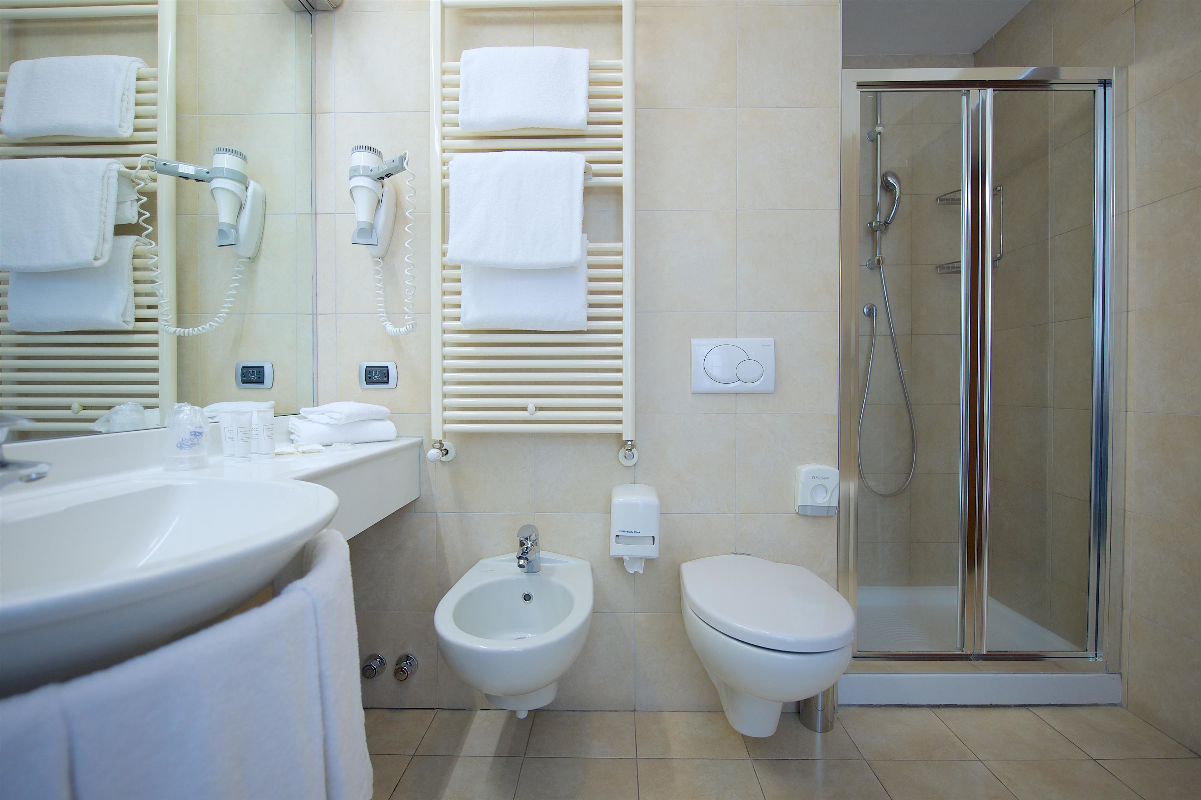 Ein modernes Badezimmer mit Waschbecken, Bidet, Toilette und einer Duschkabine.