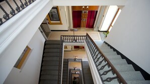 A grand staircase with a black and white railing, leading to a red elevator. - Best Western Crystal Palace Hotel (Turin)