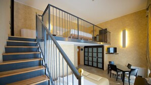 A hotel room with a staircase, a bed, a desk, and a television. - Best Western Crystal Palace Hotel (Turin)