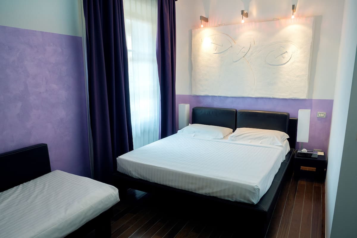 Een hotelkamer met een bed, nachtkastje en bedtafel.