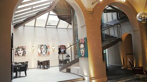 A spacious lobby with a staircase, a dining area, and artwork on the walls.