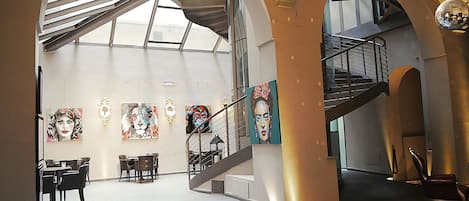 Un vestíbulo espacioso con una escalera, un comedor y obras de arte en las paredes.