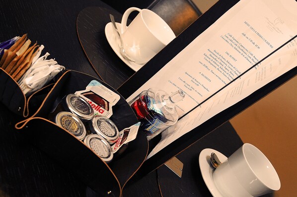 A menu with various food and drink options, a cup, and a tray with condiments and a bottle.