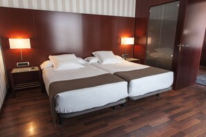 A double bed room with two bedside tables, each with a lamp, and a wooden floor. - Hotel Zenit Valencia (Valencia)