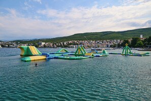 A water park with inflatable play structures and a cityscape in the background. - Hotel Selce (Crikvenica)