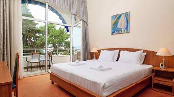 Habitación superior | Escritorio, cortinas blackout y tabla de planchar con plancha