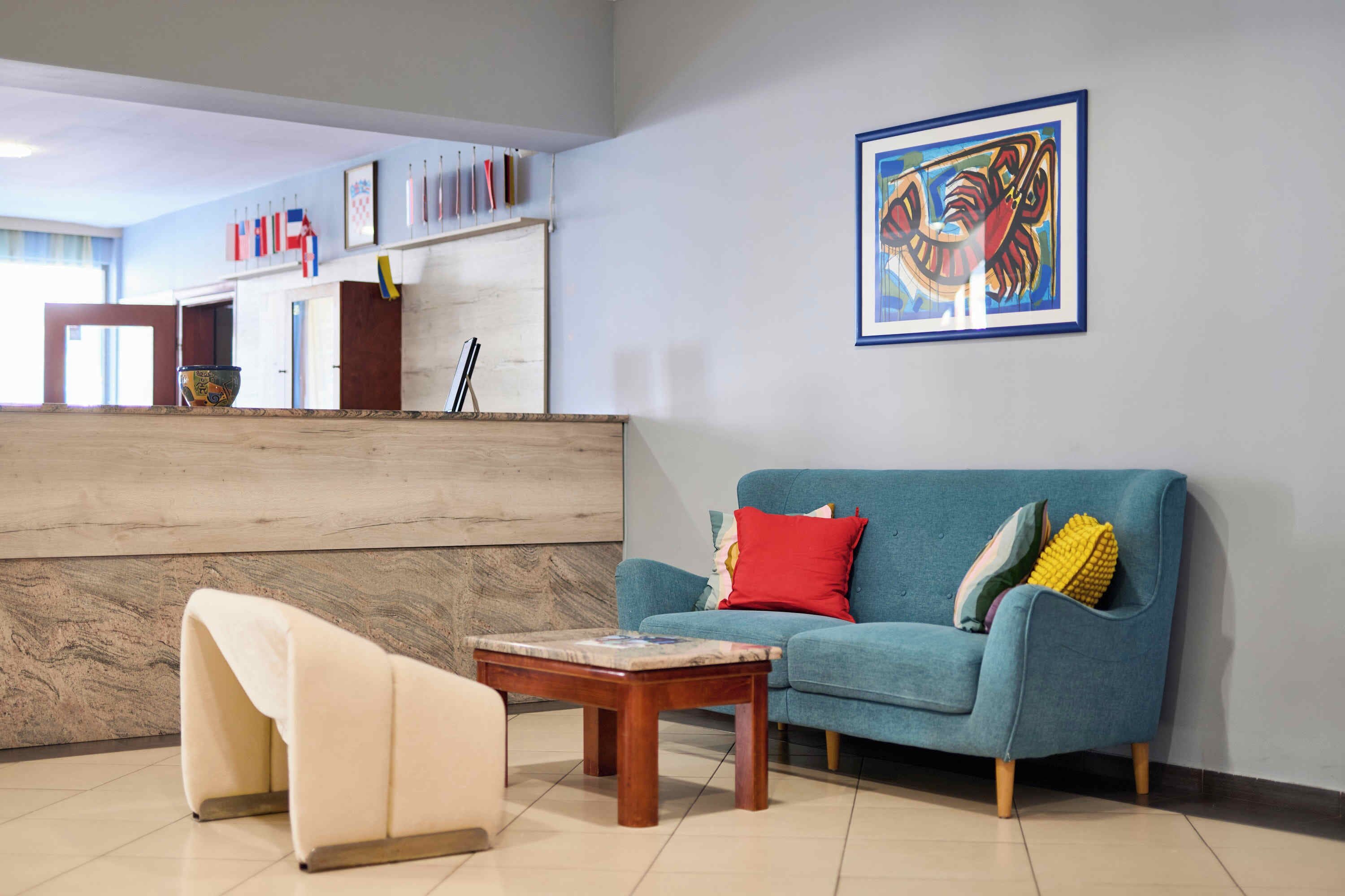Ein modernes Wohnzimmer mit einem blauen Sofa, einem Holztisch und einem weißen Sessel.