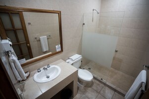 A bathroom with a sink, toilet, and glass shower enclosure.