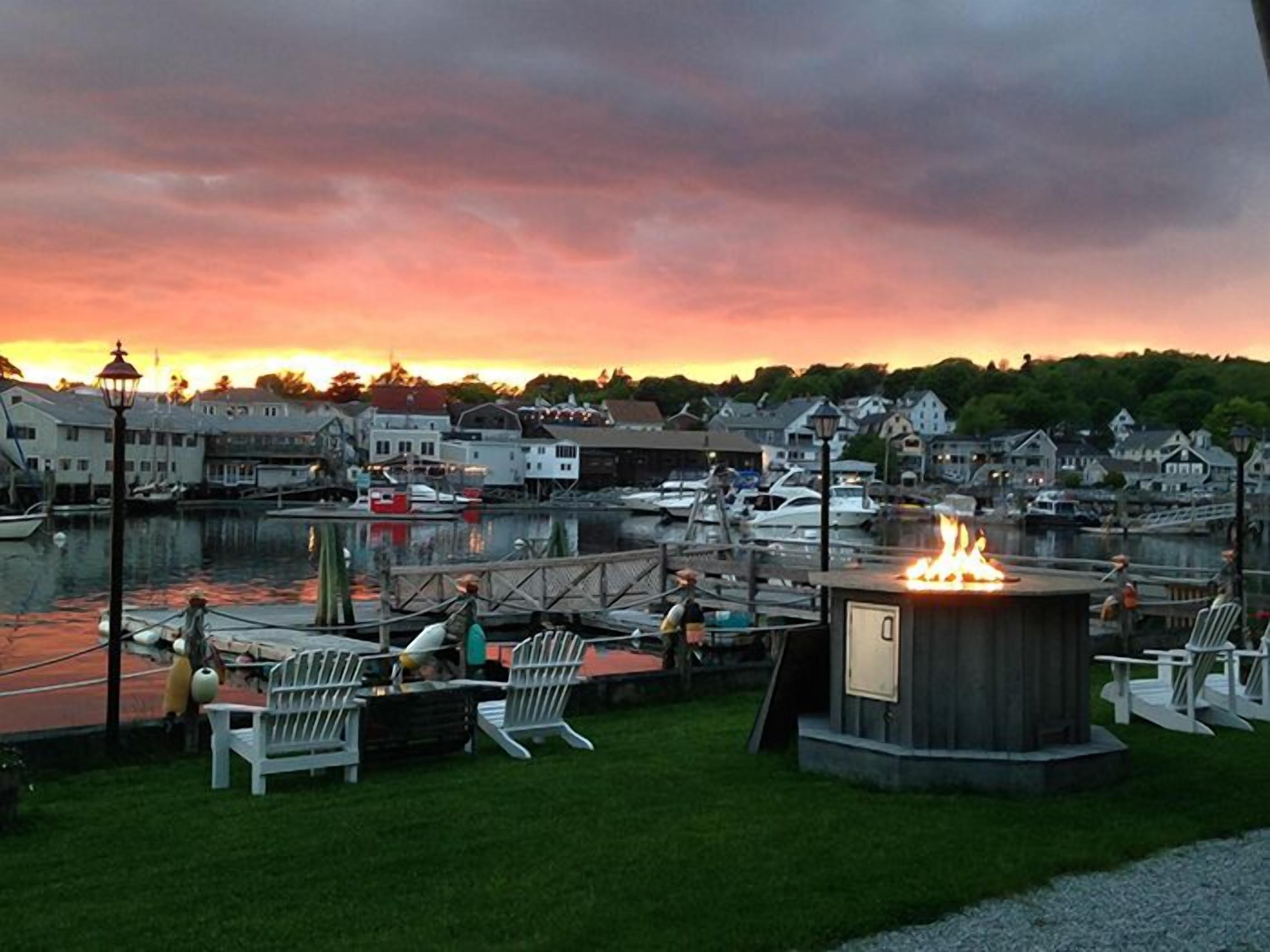 A marina with boats docked, a fire pit, and outdoor seating.