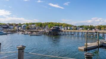 A waterfront marina with docked boats, a wooden pier, and residential buildings in the background.