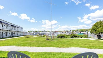 A grassy area with a flagpole and American flag, a building with a white facade, and a clear sky.