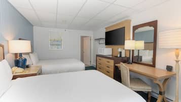 A hotel room with two beds, a desk, a chair, a television, and a microwave.