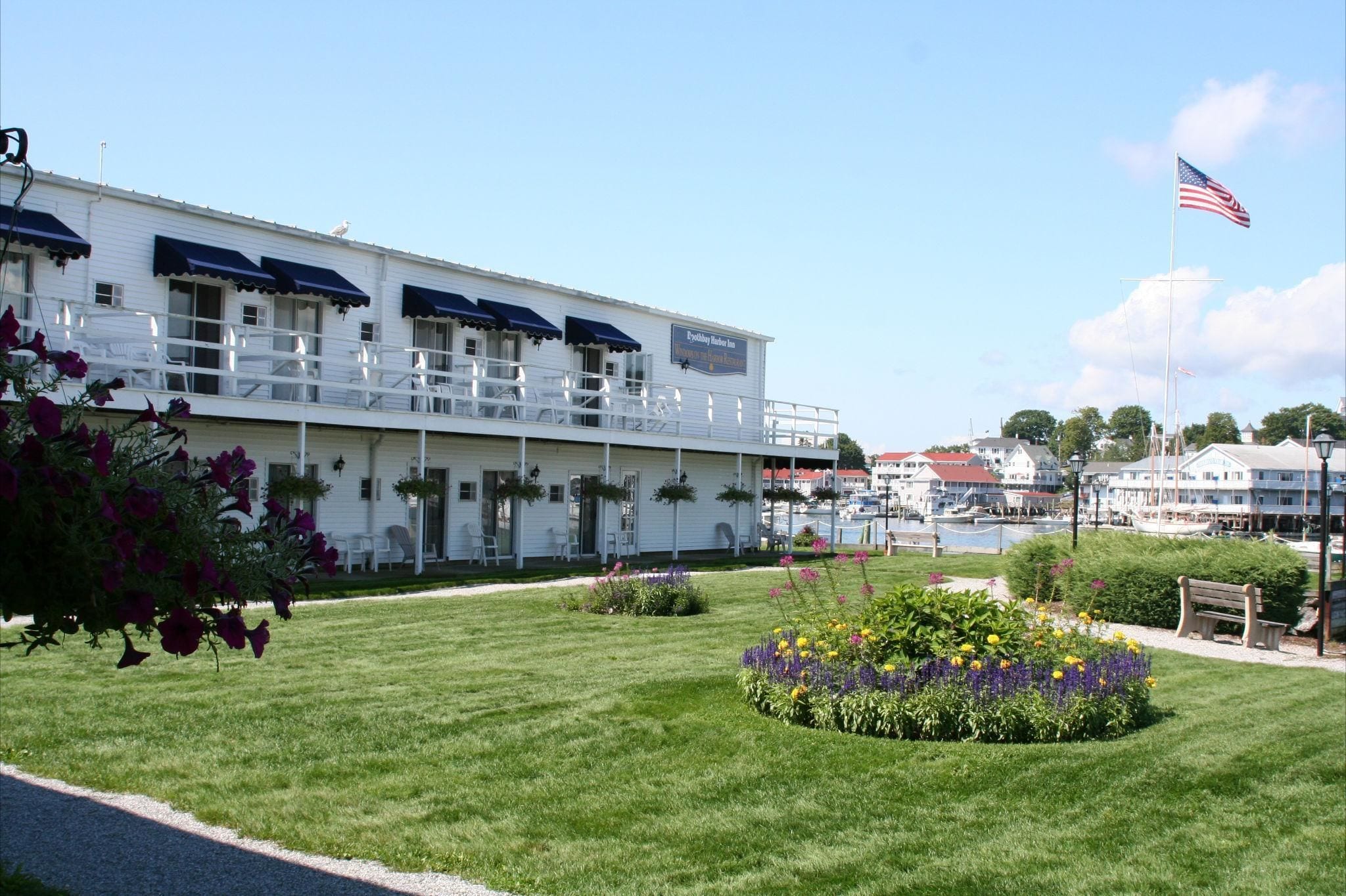 A waterfront hotel with a white exterior, multiple balconies, and a flag.