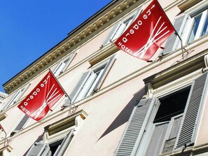 Un edificio con varias ventanas y balcones, algunos con contraventanas.