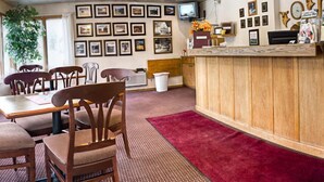 A cozy restaurant with wooden furniture, a red carpet, and a wall adorned with framed pictures. - Big Sky Motel (Superior)