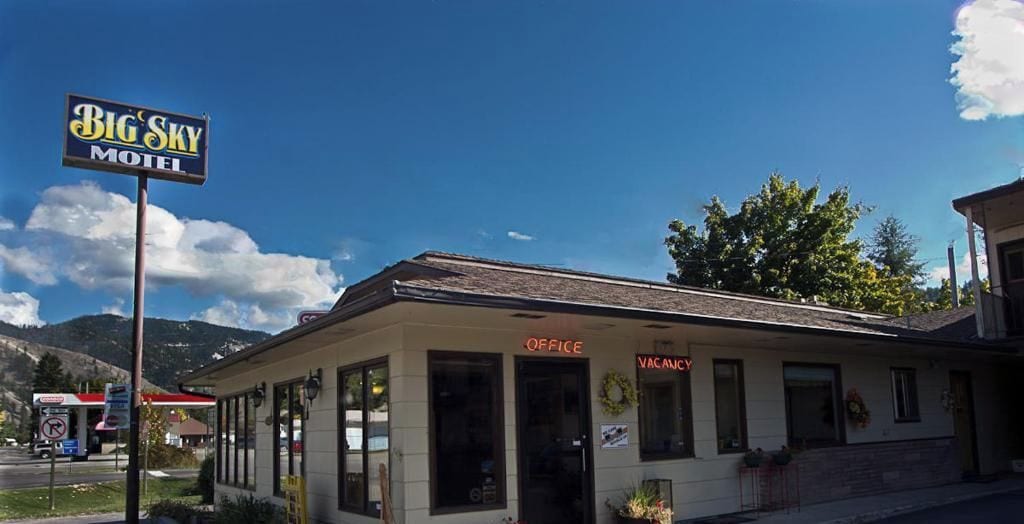 Un motel avec un panneau indicateur, un bureau et une entrée bien visible.