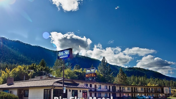 A motel with a sign reading "Big Sky Motel" against a backdrop of mountains and a clear sky. - Big Sky Motel (Superior)