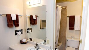 A bathroom with a sink, mirror, towel rack, and toilet. - Big Sky Motel (Superior)