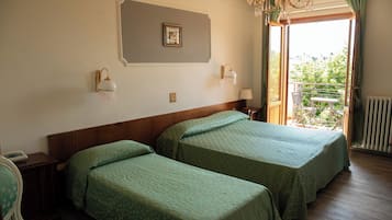 Ein Hotelzimmer mit zwei Betten, einer Chandelier, einem Balkon mit Aussicht und einem gerahmten Bild an der Wand.