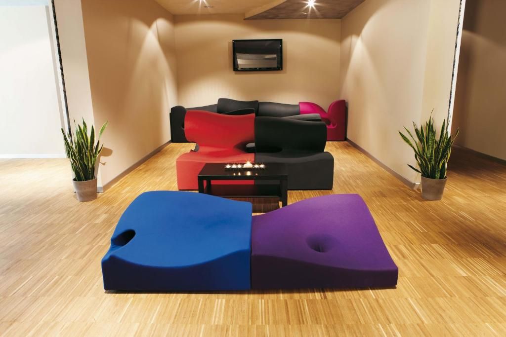 A modern living room with a sofa set, a coffee table, and two potted plants.