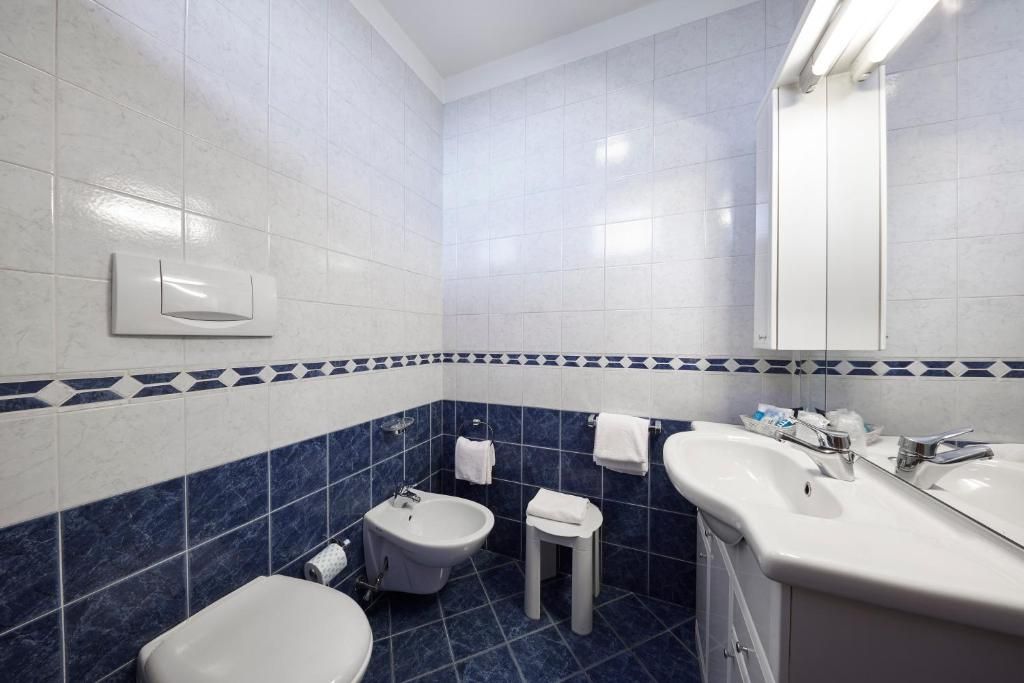 Un bagno con bidet, lavandino e specchio.
