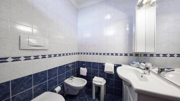 Un bagno con bidet, lavandino e specchio.