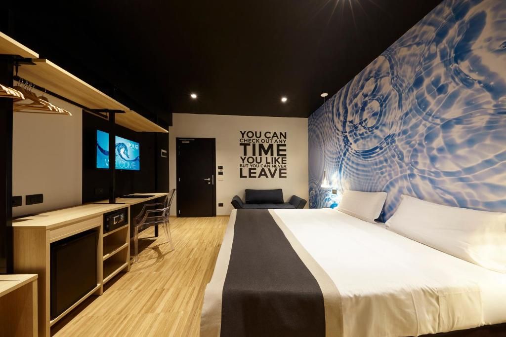 Una habitación de hotel moderna con una cama grande, un escritorio y una televisión.