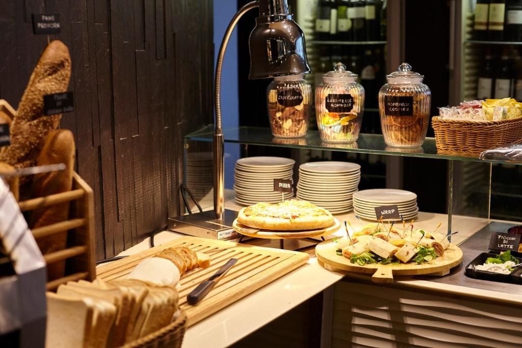Ein Buffet mit verschiedenen Speisen, darunter Pizza, Sandwiches und einer Auswahl an Käse.