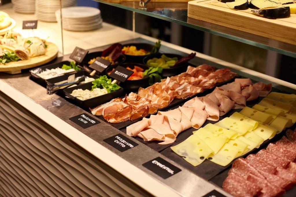A deli counter with various meats and cheeses, including prosciutto, salami, and mozzarella.