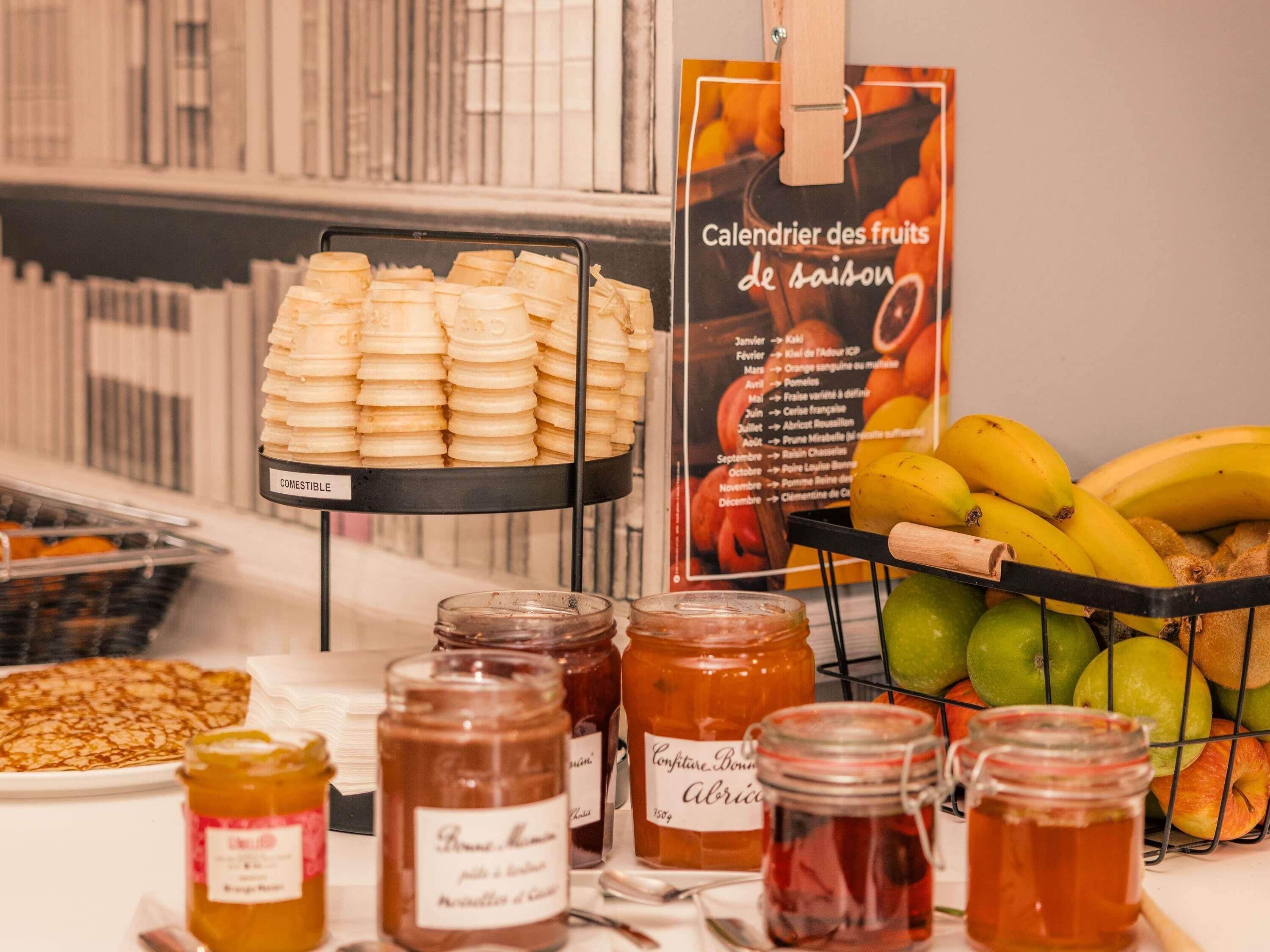 Eine Auswahl an Lebensmitteln, darunter Gläser mit Marmelade, eine Bananenkiste und ein Korb mit Keksen.