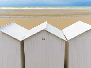 Trois cabanes de plage, dont l’une porte le numéro « 118 ».