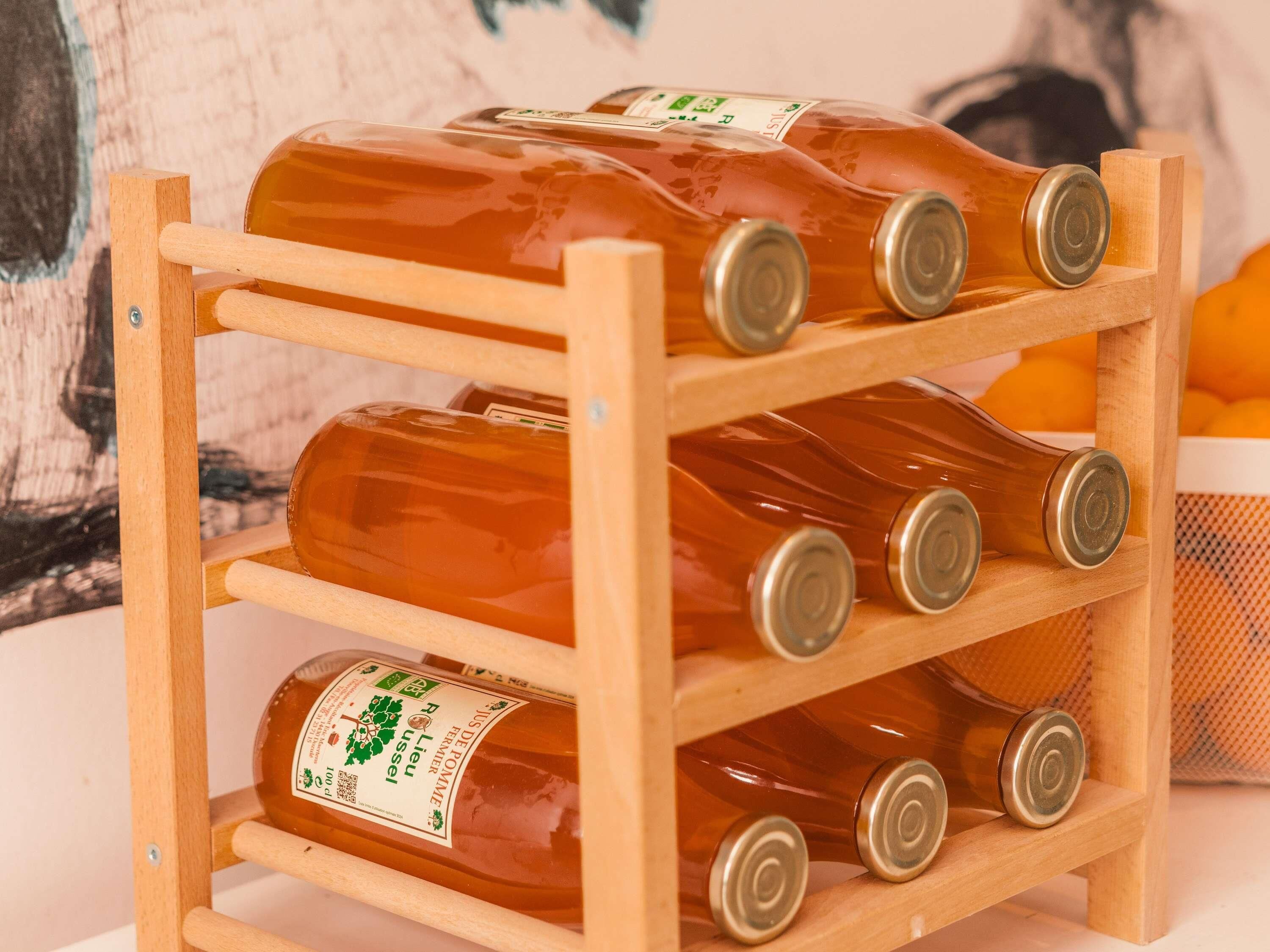 Ein Holzkasten mit mehreren Flaschen eines Getränks mit Etiketten.