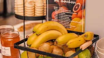 Una exposición de frutas con plátanos, manzanas y pan.