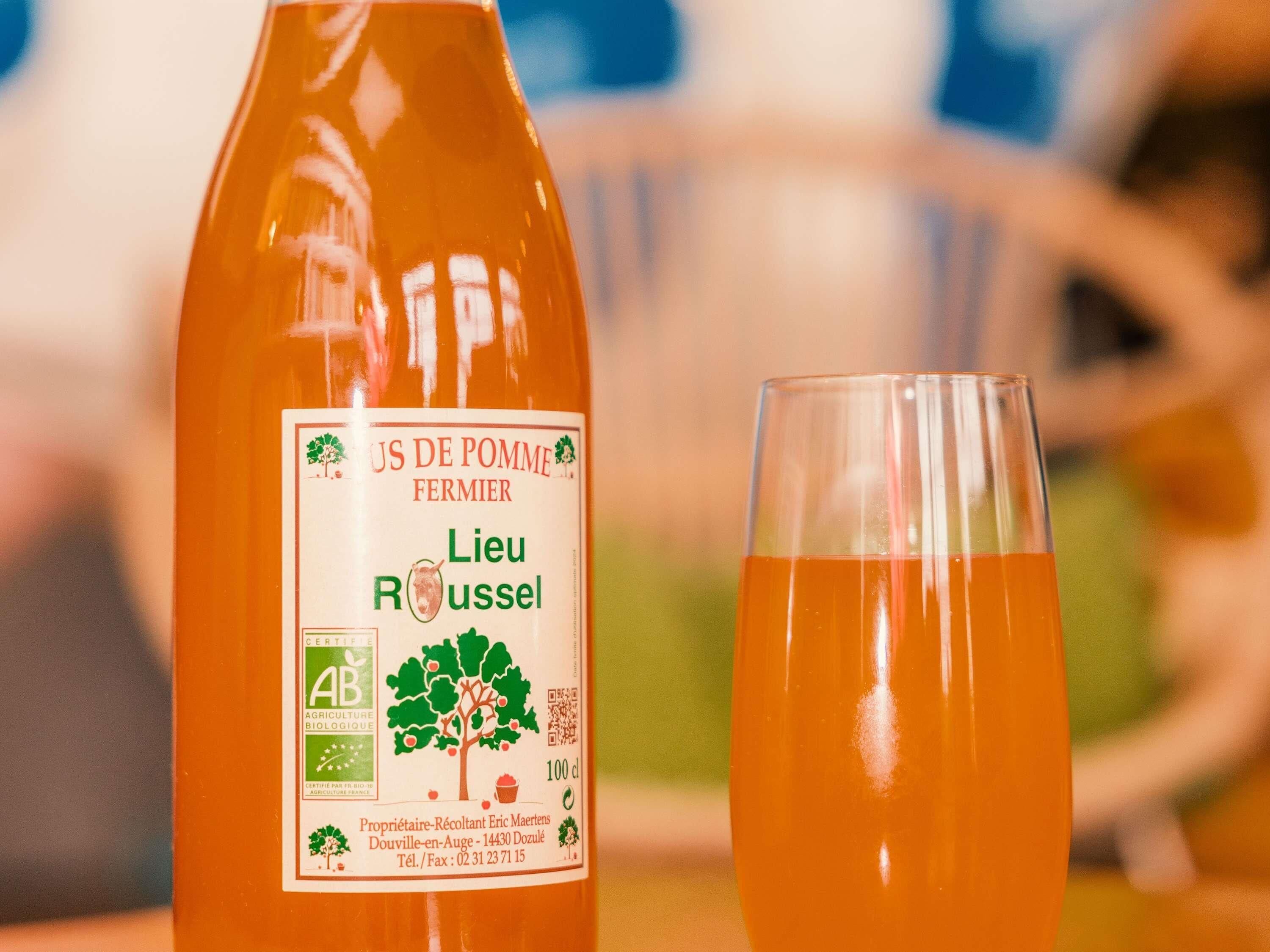 A bottle of 'Lieu Rousseau' wine and a glass filled with the same liquid.