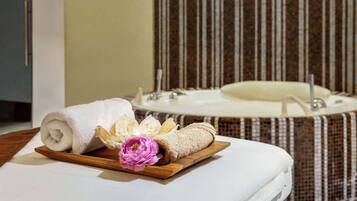 Relax in a clean and inviting bathroom with a large round bathtub and striped walls.