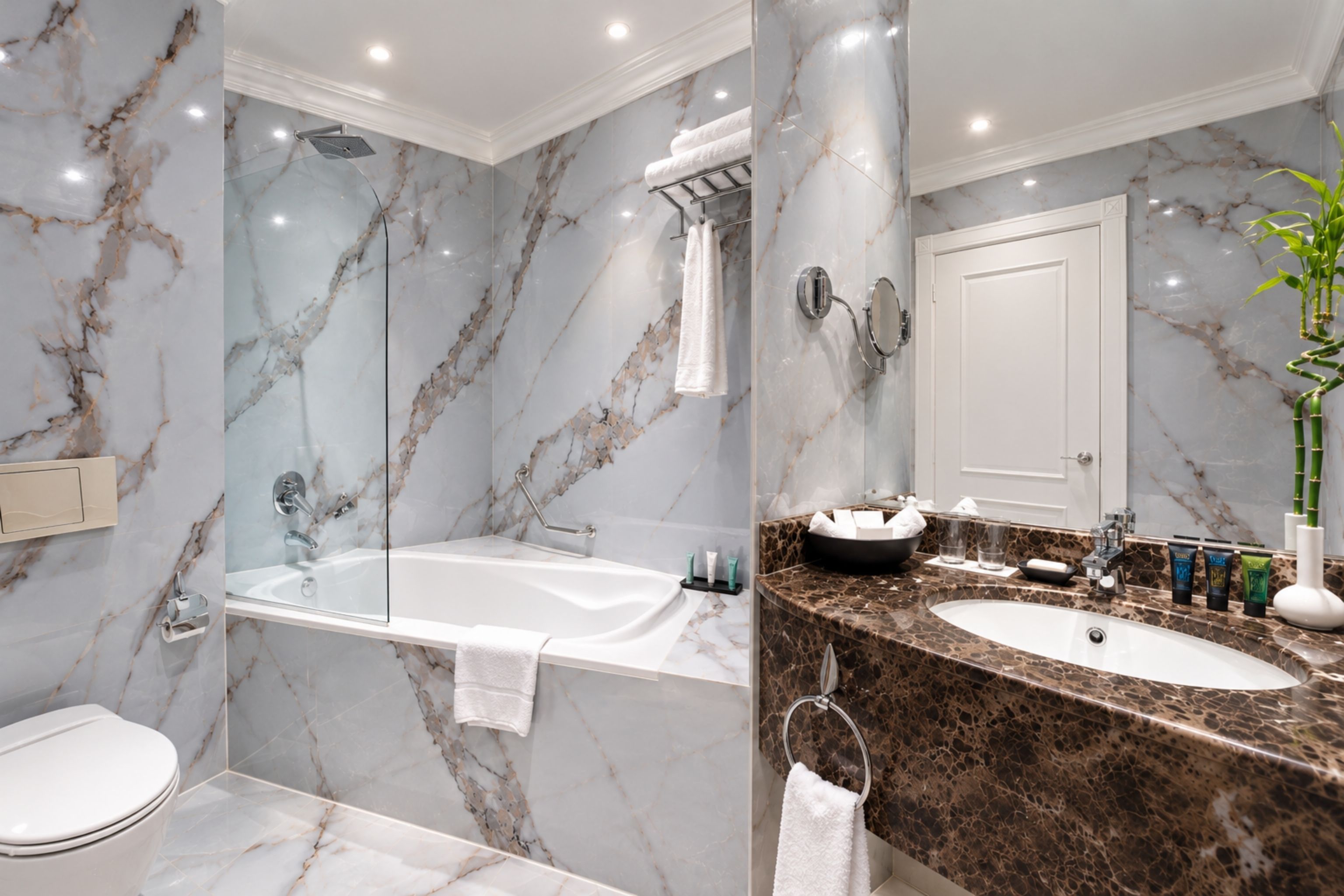 A modern bathroom with a marble floor, a bathtub, a shower, and a vanity with a sink and mirror.