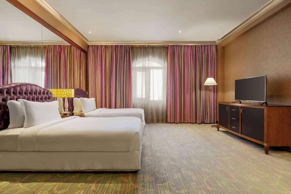 Una habitación de hotel con una cama grande, televisión y un armario.