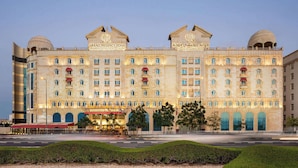 A large, historic building with multiple balconies and arched windows, labeled "GRAND REGENCY DOHA".