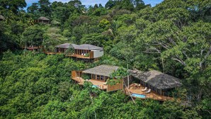 A resort with multiple wooden structures surrounded by dense forest, including a pool area. - Lapa Rios Lodge (Puerto Jiménez)