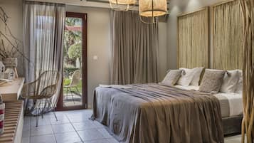 Un dormitorio con cama, una silla, un ventanal y cortinas.