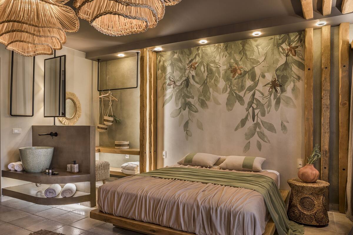 A modern bedroom with a large bed, a built-in sink, and a wall-mounted mirror.