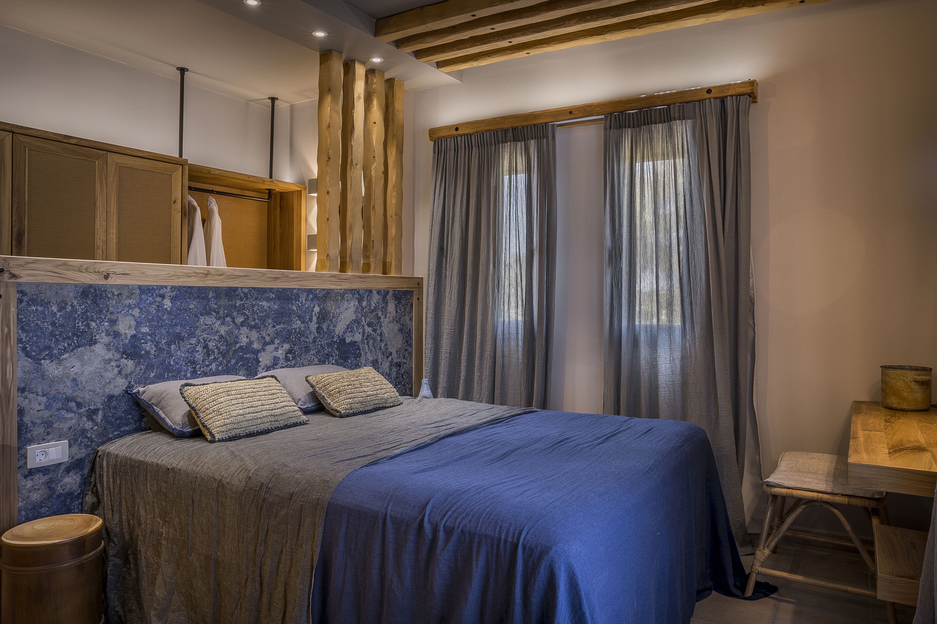 A bedroom with a bed, wooden headboard, and a desk with a chair.