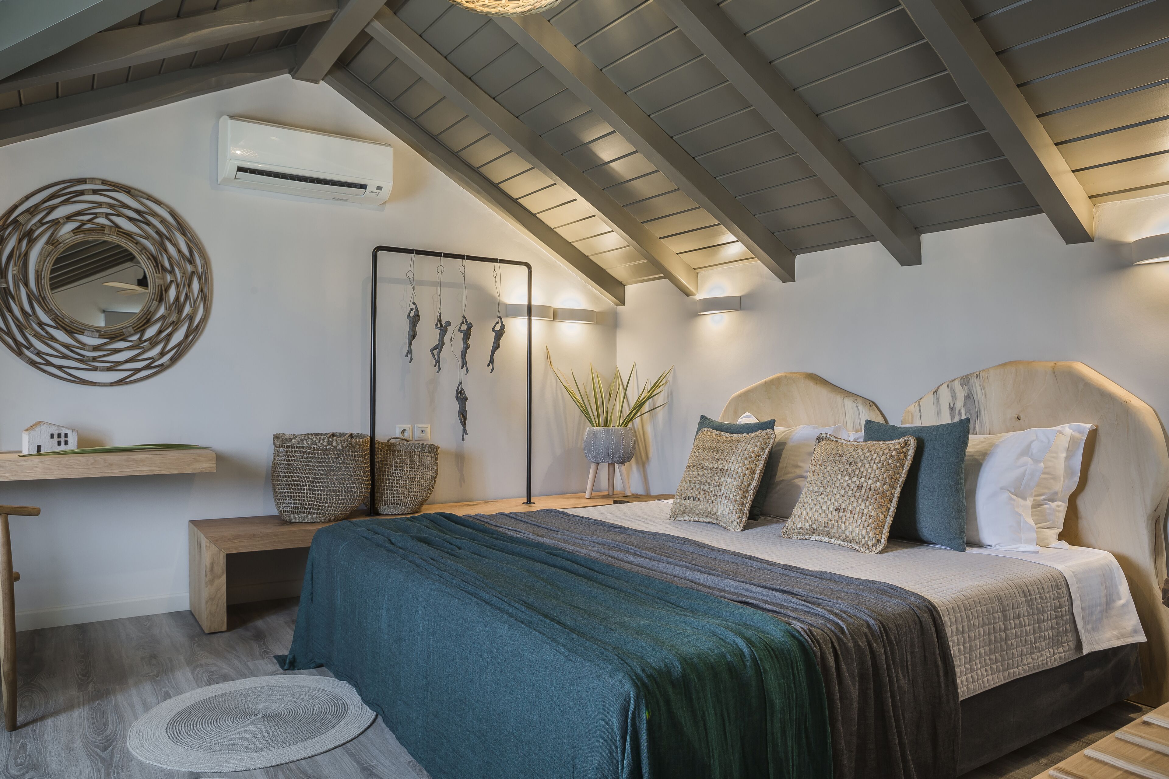 A bedroom with a bed, bedside table, and a wall-mounted air conditioner.