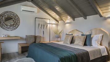 A bedroom with a bed, bedside table, and a wall-mounted air conditioner.