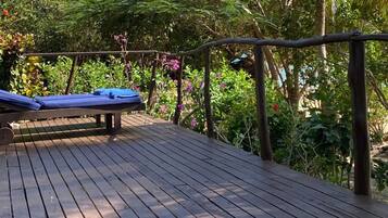 A wooden deck with a lounge chair and a pergola.
