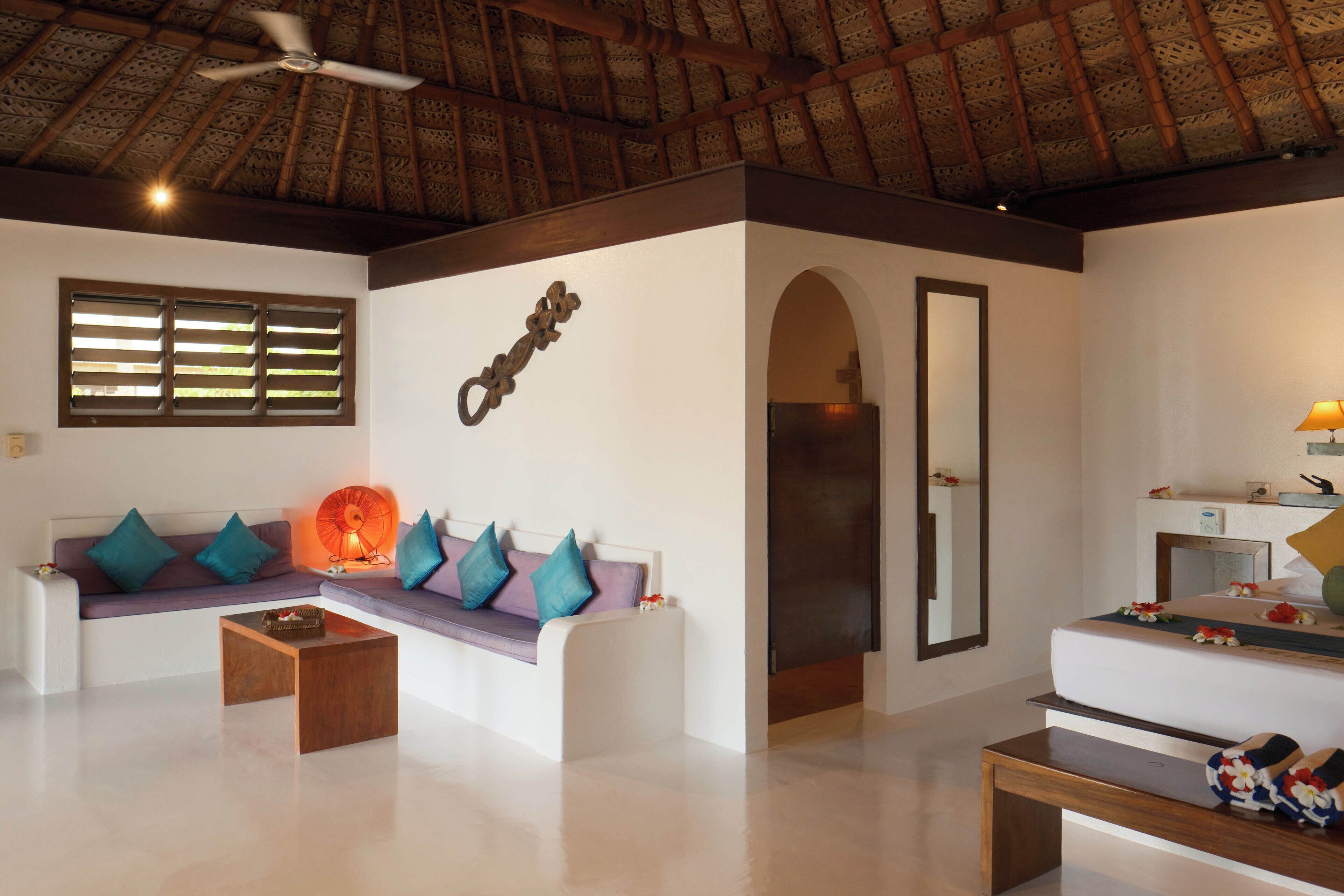 A modern living room with a sofa, coffee table, and a ceiling fan.
