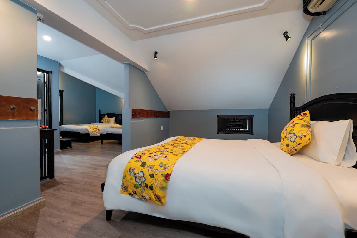 A bedroom with a large bed, a smaller bed, and a desk.